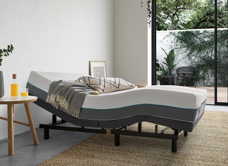 A fully adjustable Sleepmotion platform bed, dressed in a simple white room with botanical elements.