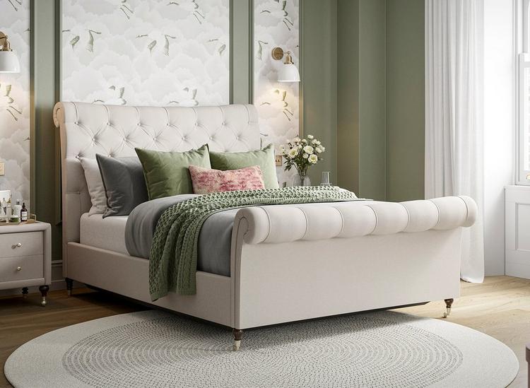 Beige upholstered sleigh double bed, styled with pink and green bedding.