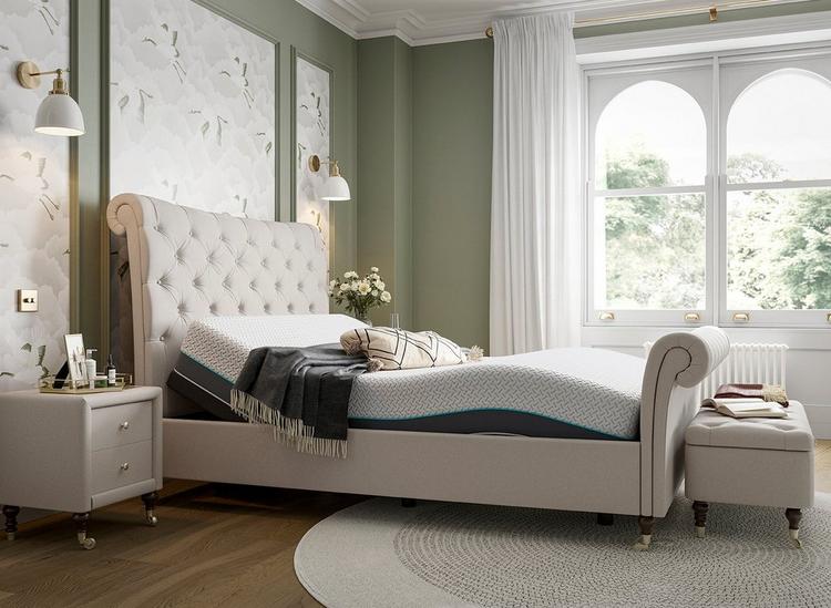 Natural tone upholstered bed frame, styled in a green botanical room with an adjustable Sleepmotion bed base
