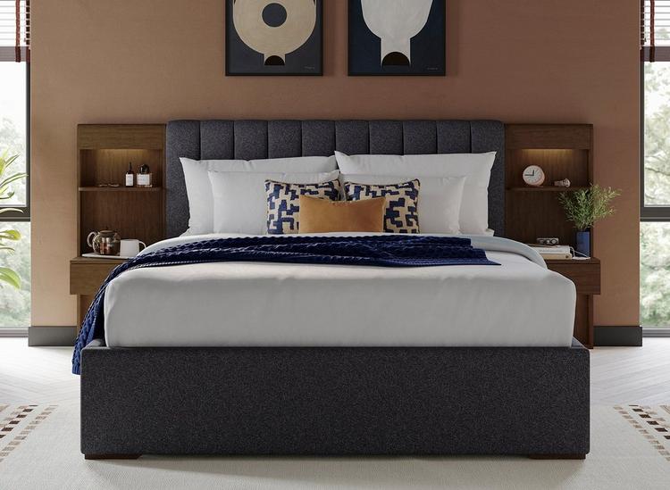 Hotel style bed with built-in bedsides, spotlights and shelves, with upholstery and wooden finishes.