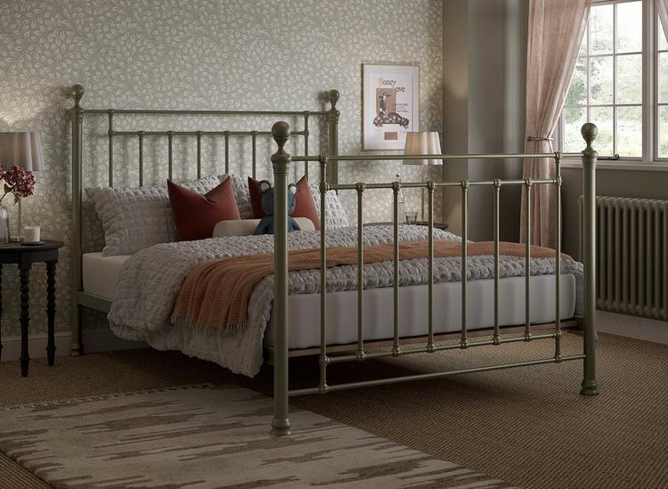 Antique-style brass metal bed frame, with traditional finials and castings, styled in a classic bedroom.