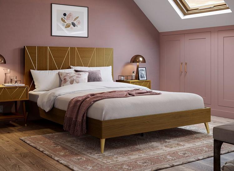 Dark wooden bed frame with gold metallic inlays, styled in a deep pink feminine bedroom.