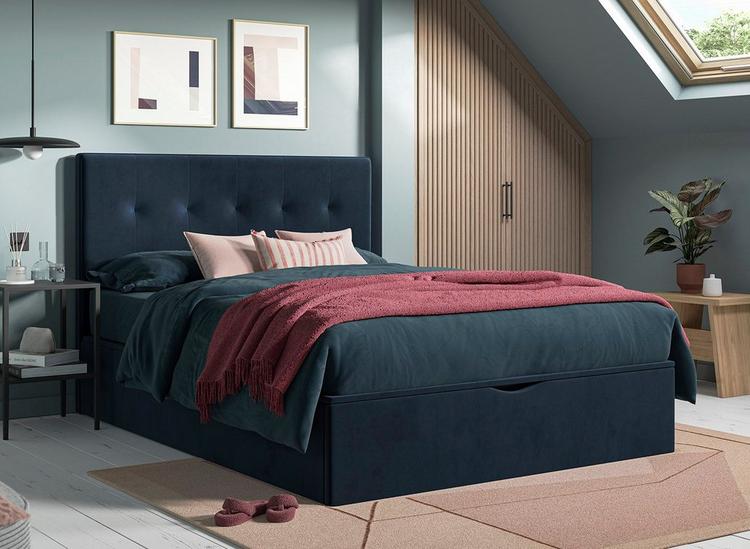 Navy blue ottoman bed with button design, styled in a duck egg blue bedroom.