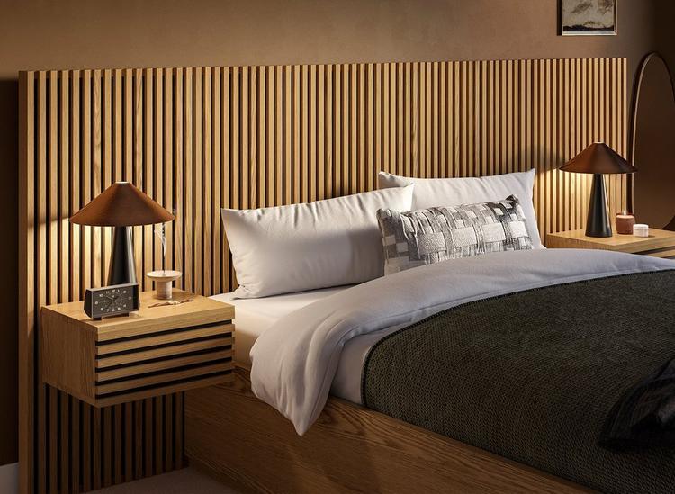 A hotel-style bed with wooden slatting and built-in bedside tables, styled against a brown wall.