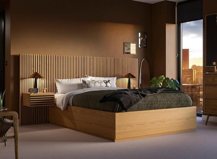 A hotel-style bed with wooden slatting and built-in bedside tables, styled against a brown wall.