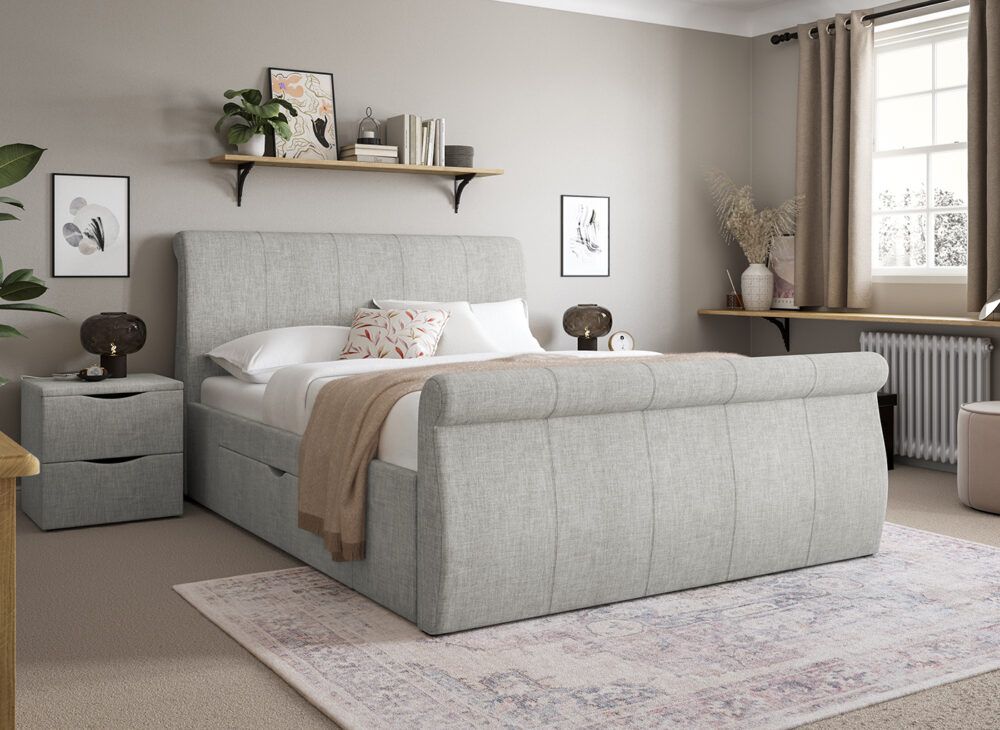 Light grey sleigh bed with matching bedside, styled in a light neutral room.