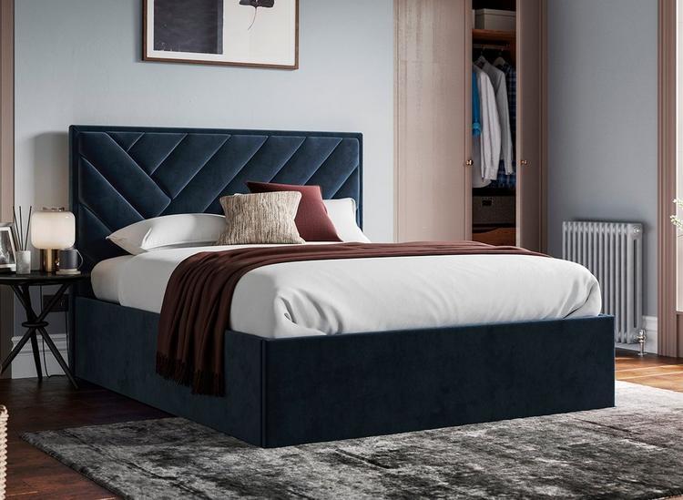 Navy blue ottoman bed with chevron design, styled in a light blue bedroom