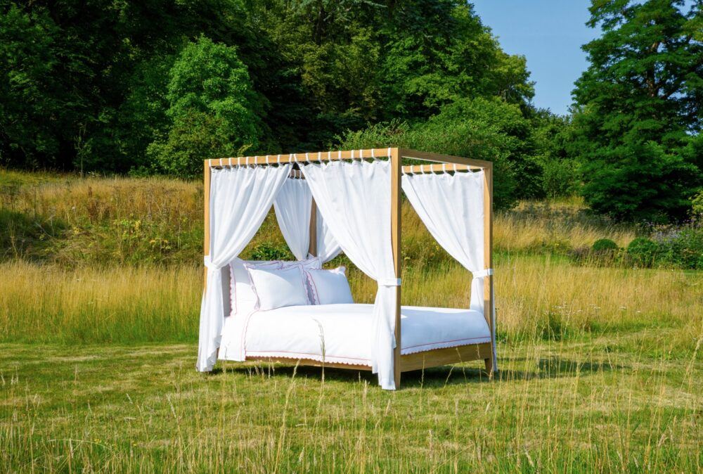 Sophie Conran Arbor four poster bed with wood and linen drapes pictured in spectacular scenery