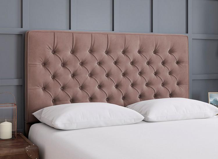 A plush velvet buttoned headboard in dusky pink