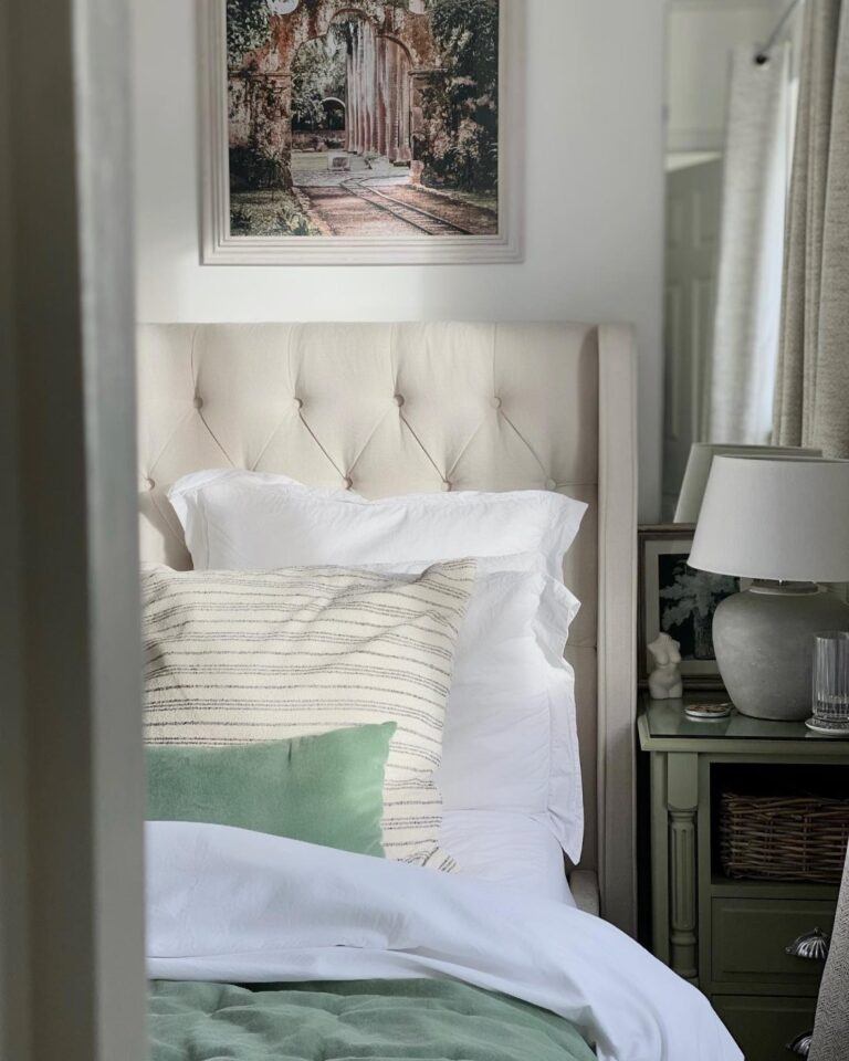 Natural-tone bed with buttoned headboard, styled with blue and green accessories.