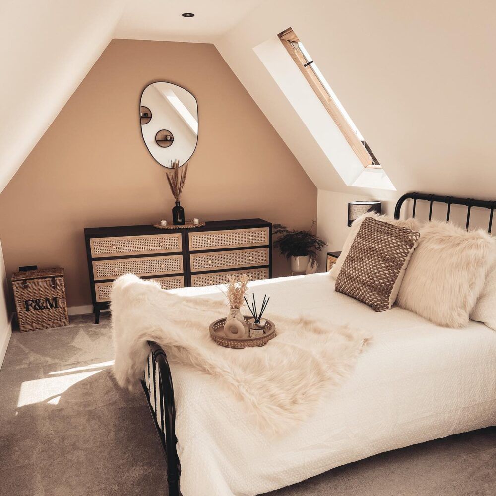 A black metal bed styled in a brown and cream room