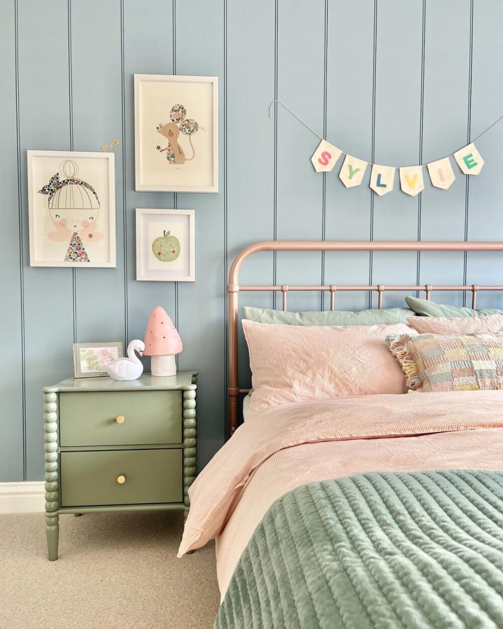Pink bed frame with light green bedding