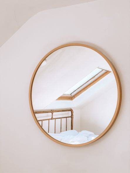 mirror on bedroom wall reflecting light from window