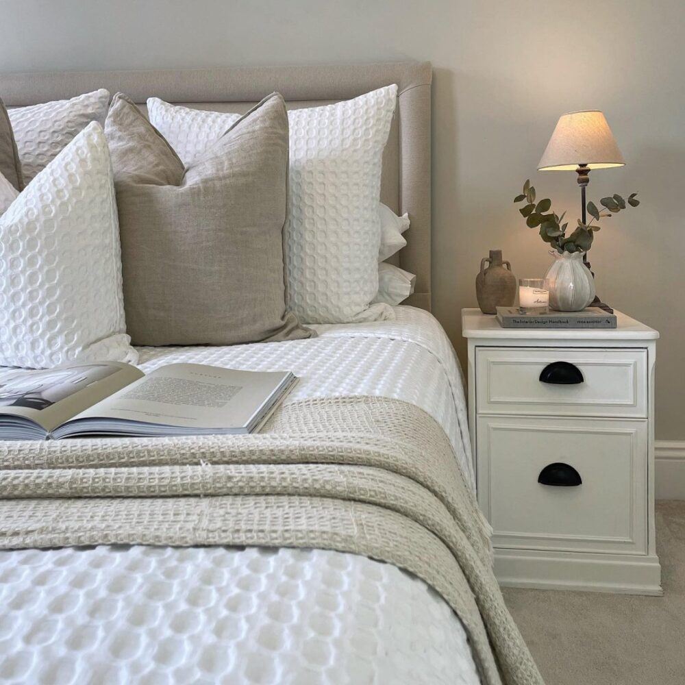 image of a zoomed in bed with cottagecore style bedding and bedside table