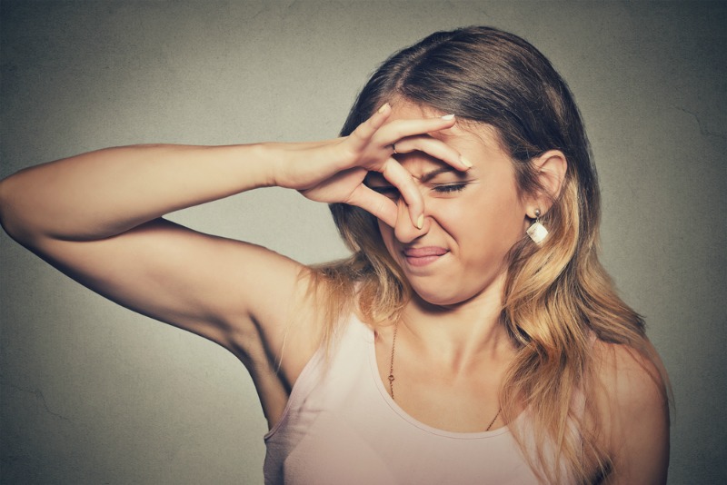 Image of woman smelling bad scent