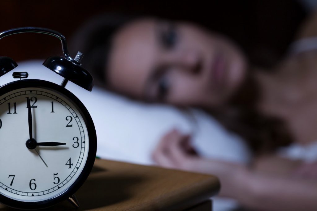 clock at early morning with woman unable to sleep