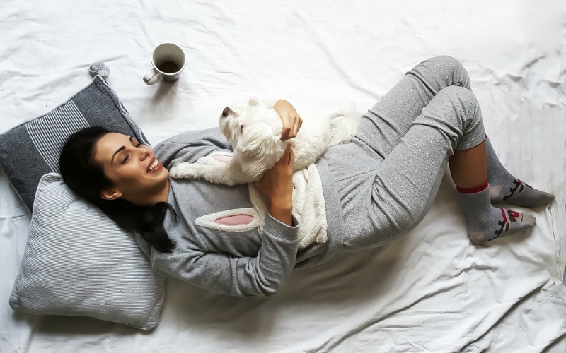 Woman and dog on bed