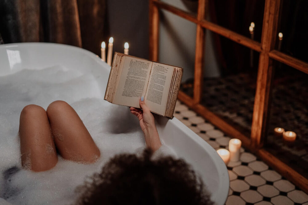 Woman in warm bubble bath reading