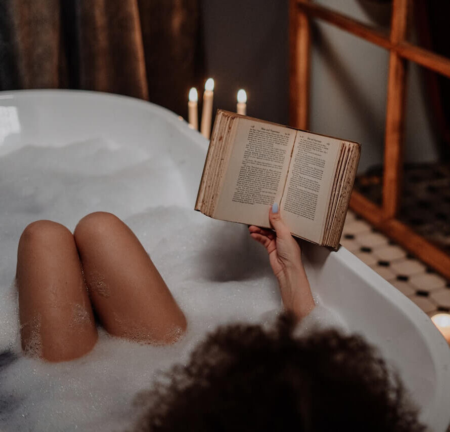 Woman in warm bubble bath reading