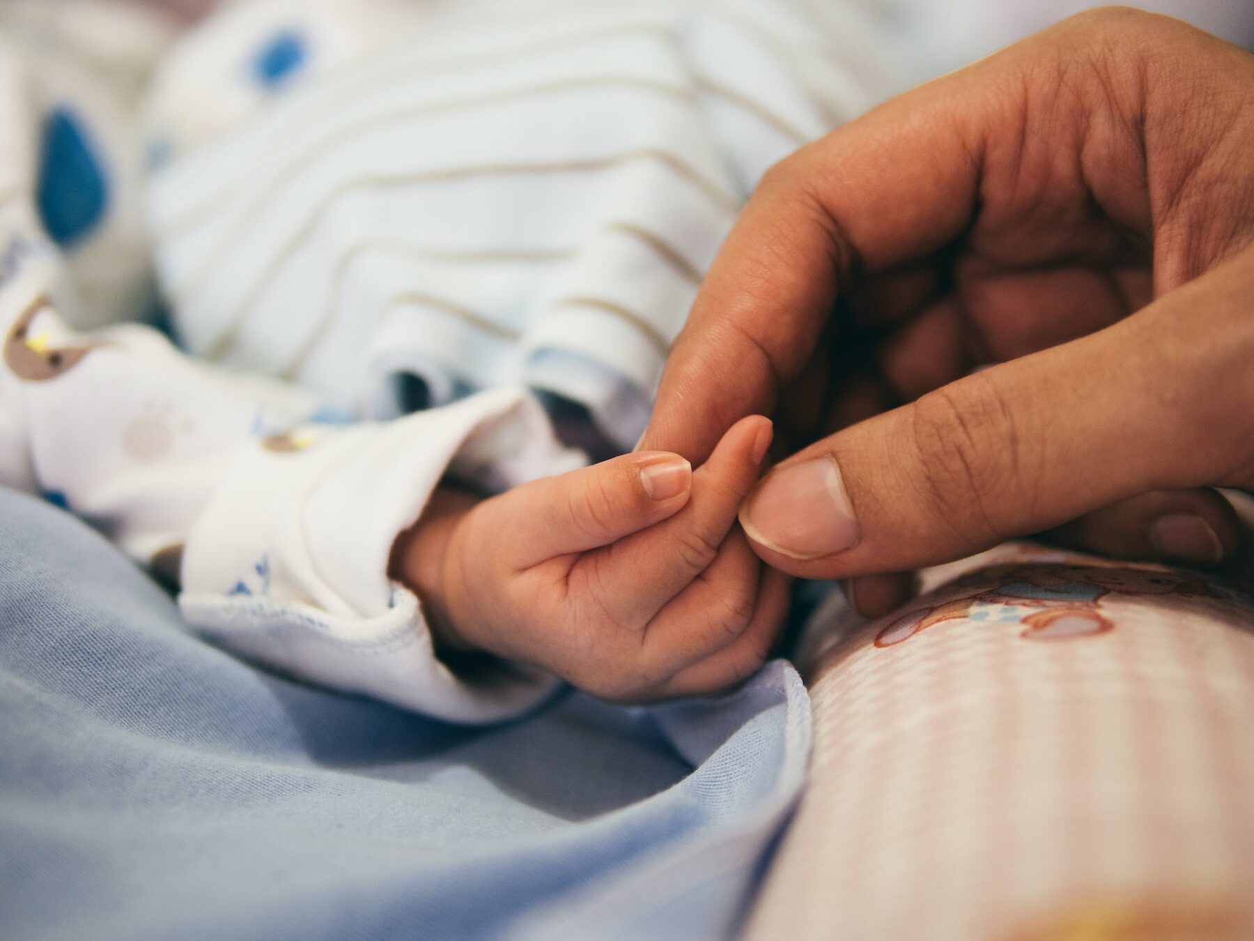 Mum holding babies finger