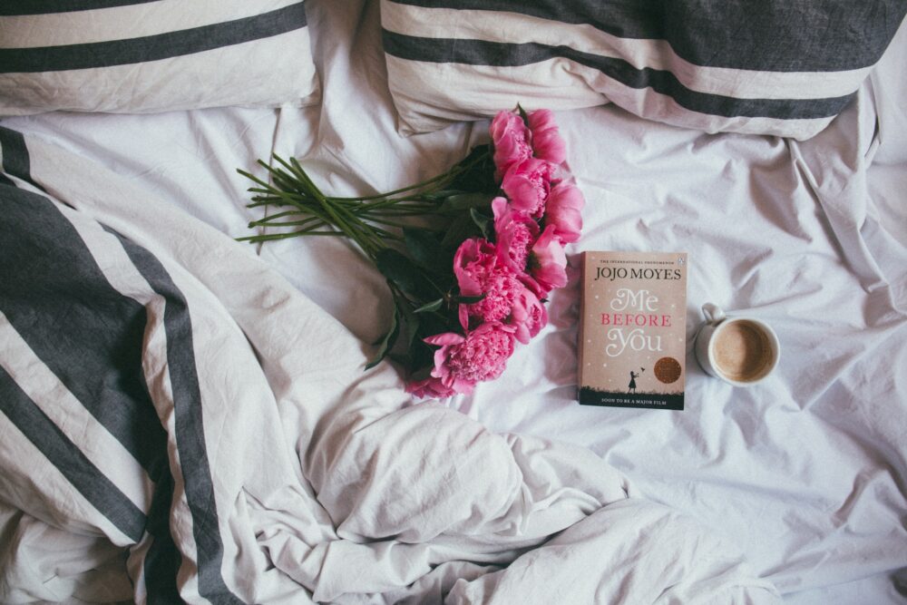 Flowers on bed with book and tea