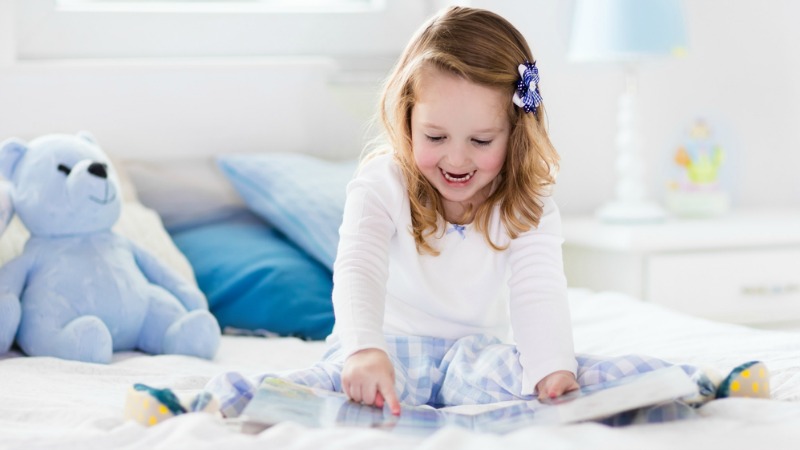 Child reading on bed
