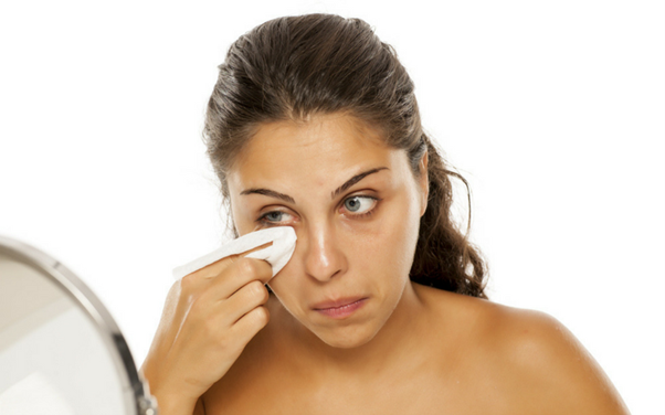 Woman cleaning her eyes