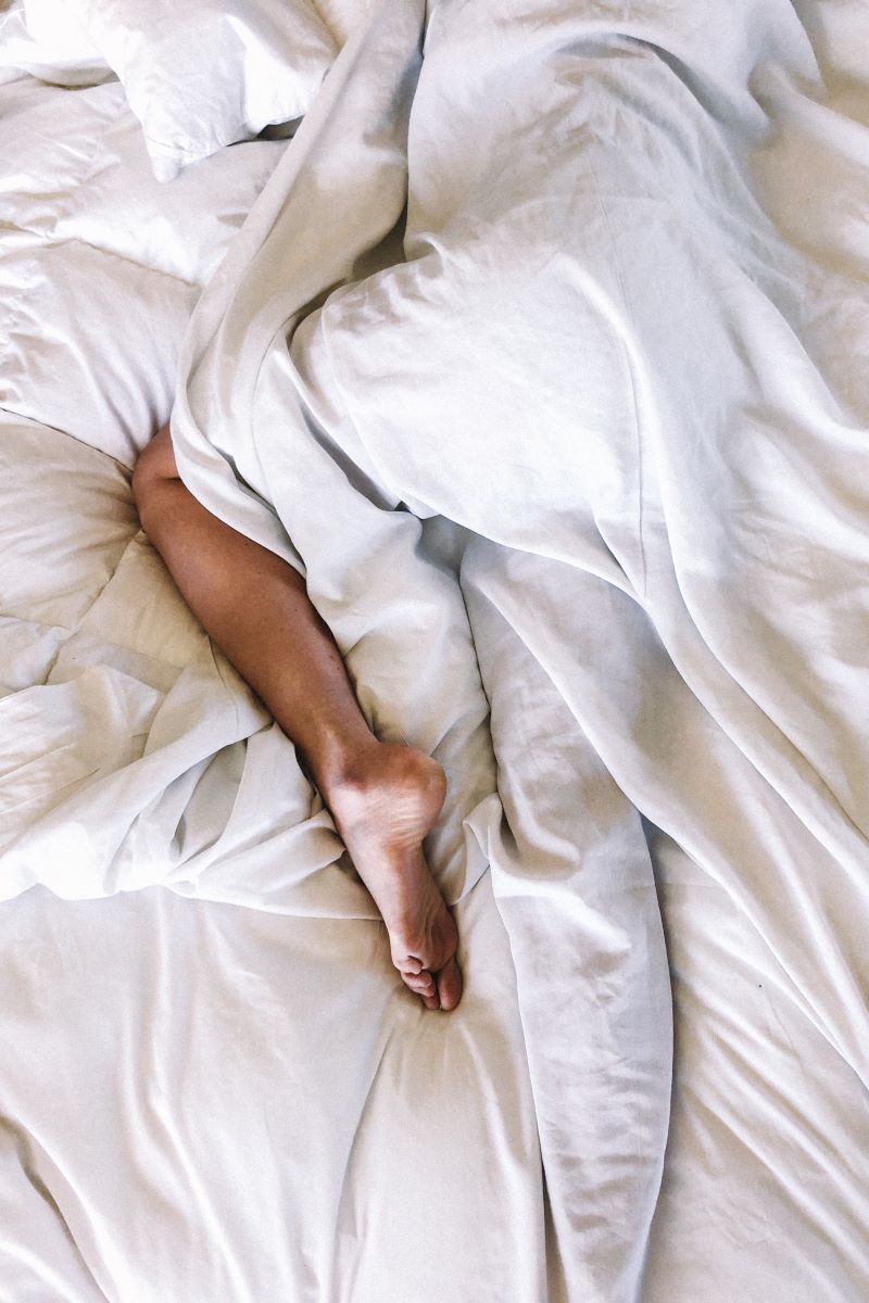 image of a person asleep with their foot out the covers