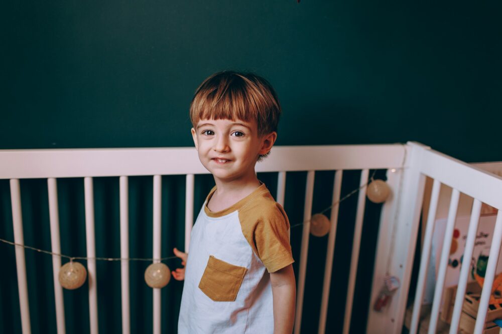 Toddler in white cot