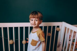 Toddler in white cot