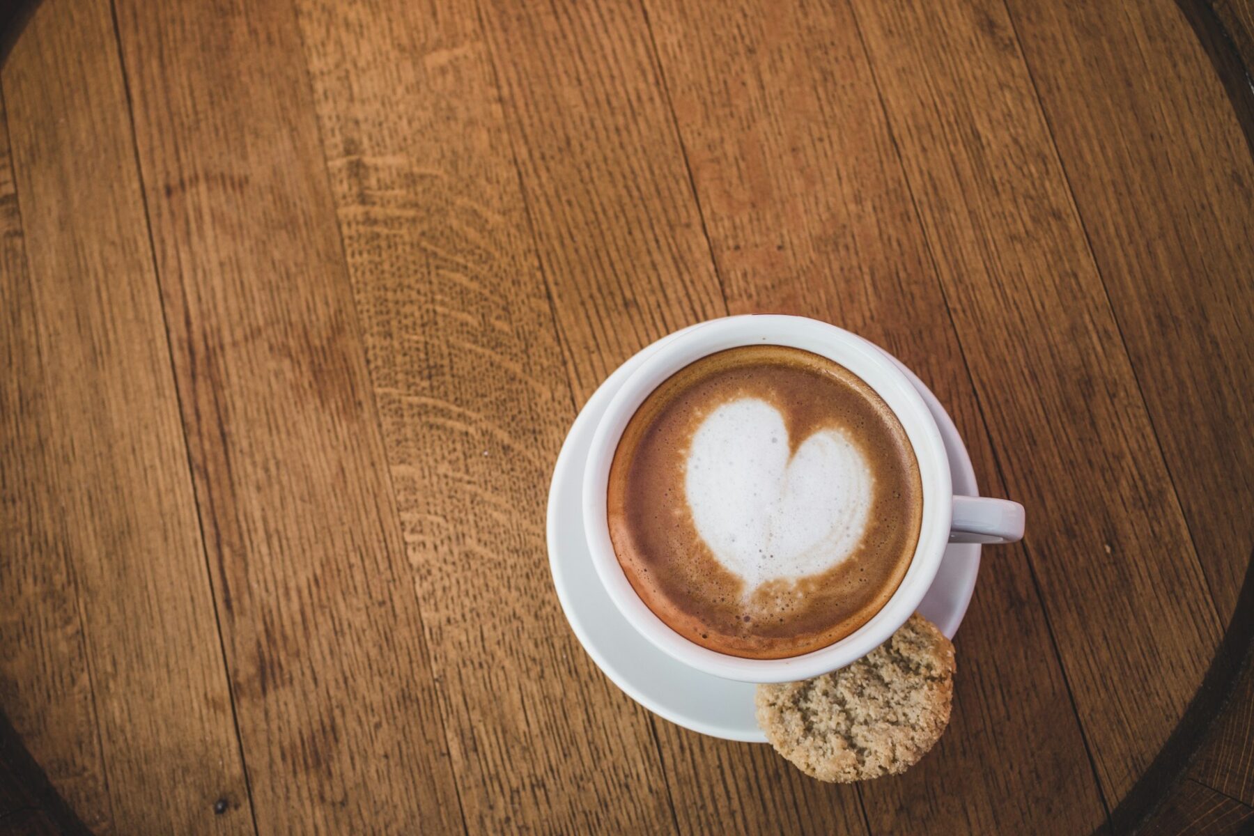 Coffee with heart pattern and a cookie