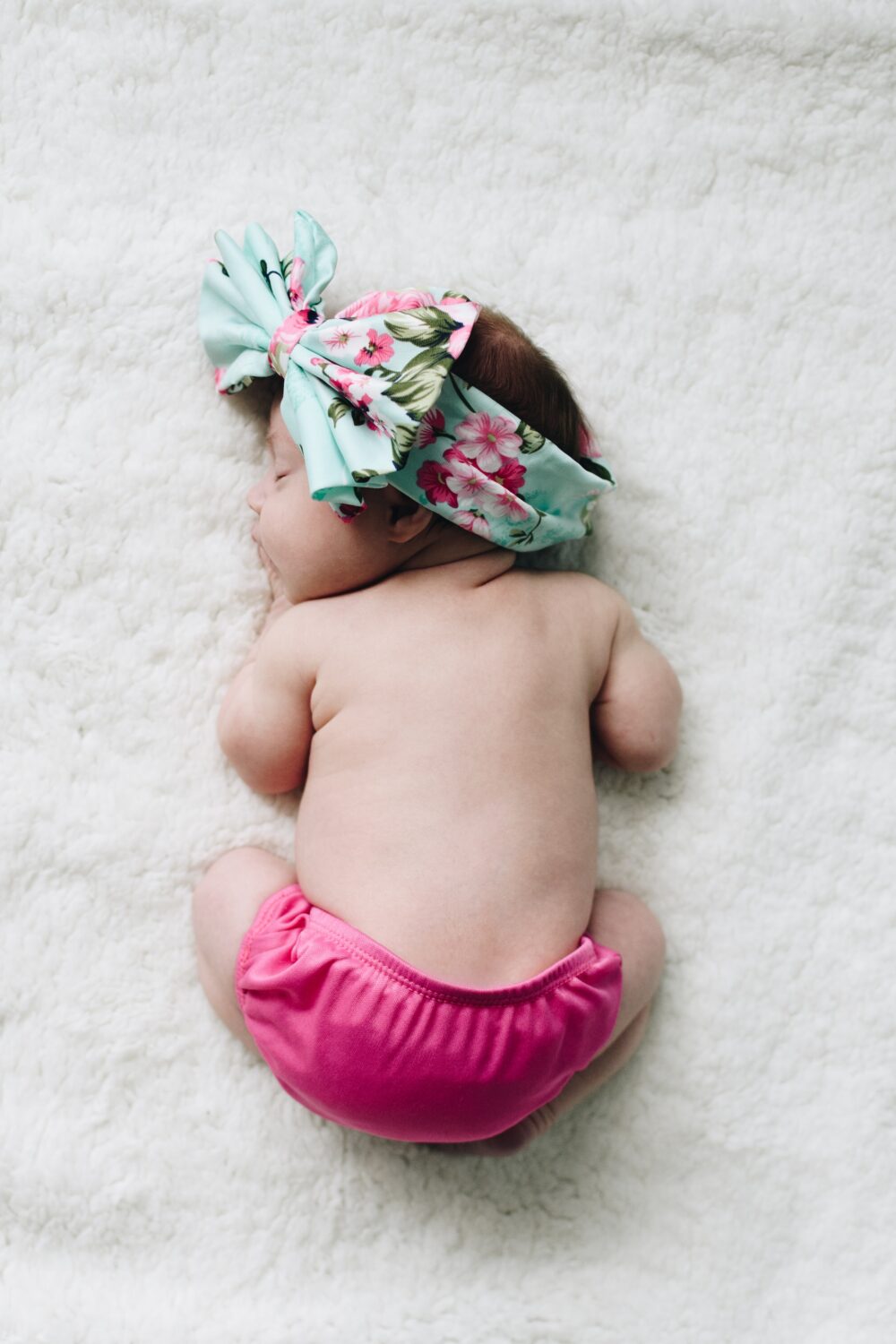 Cute baby asleep with bow in hair