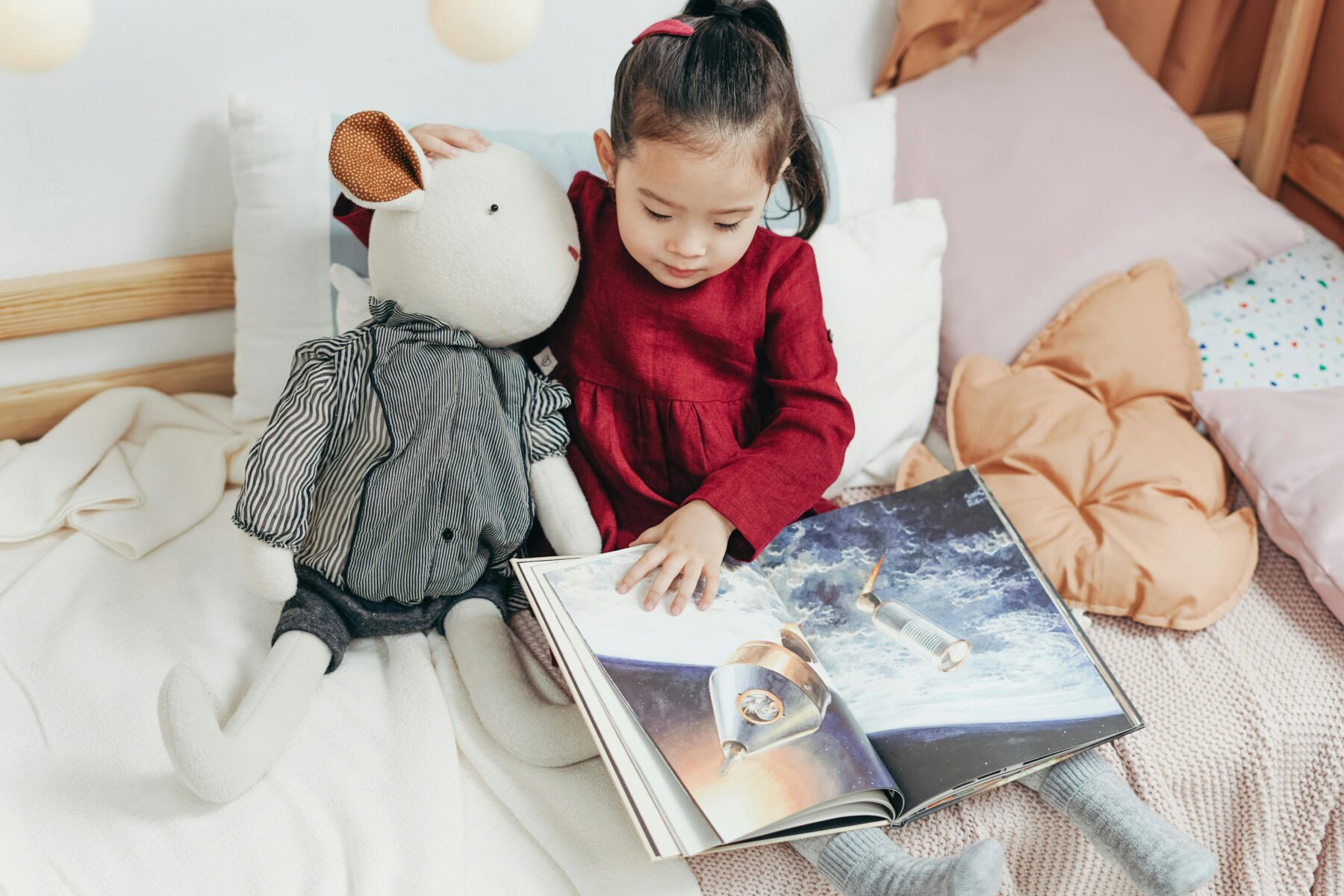 Child reading book in bed
