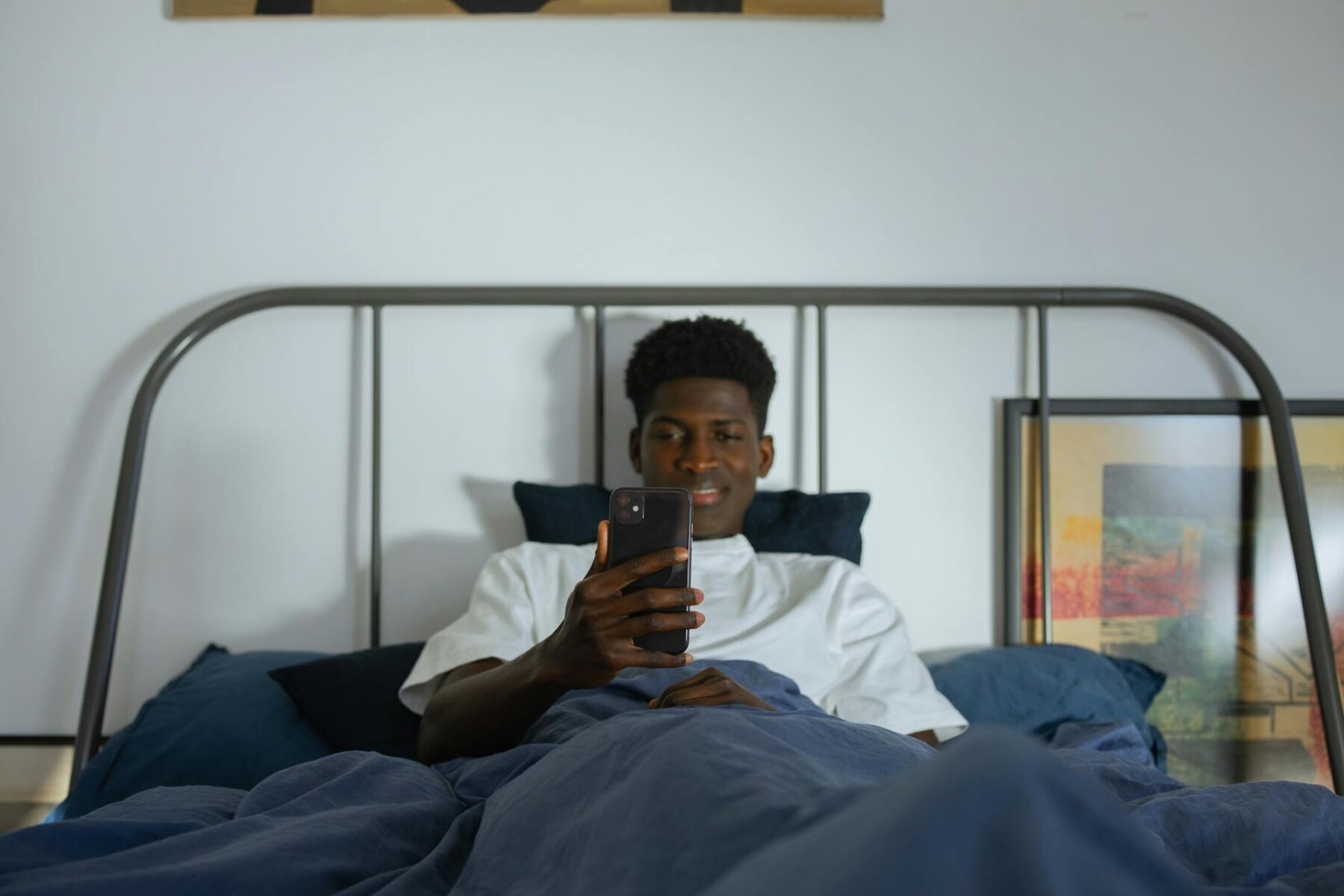 Man on his phone in bed