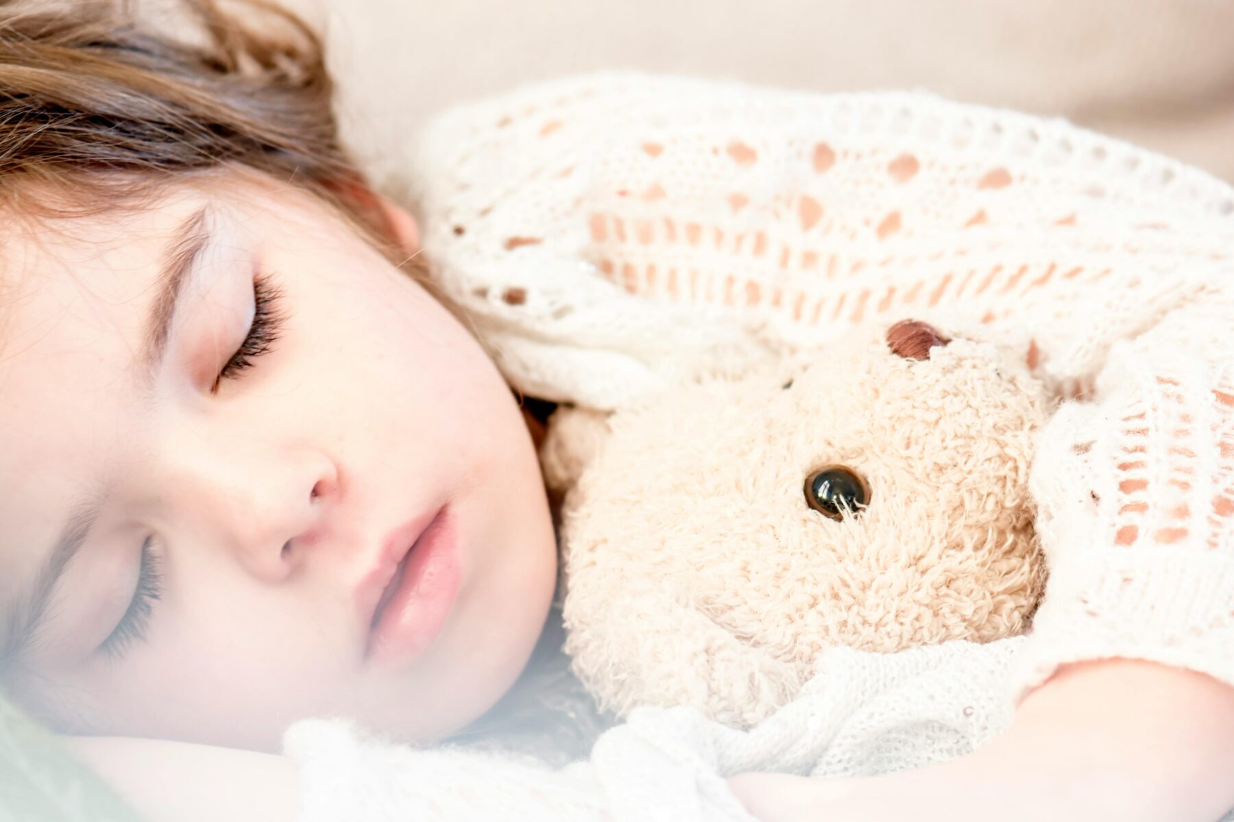 Little girl sleeping holding teddy