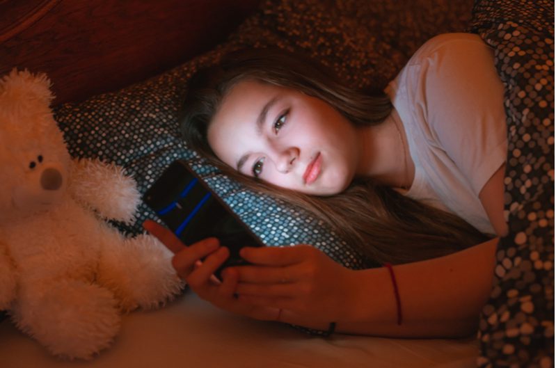 teen on phone while in bed to show poor bedtime routine