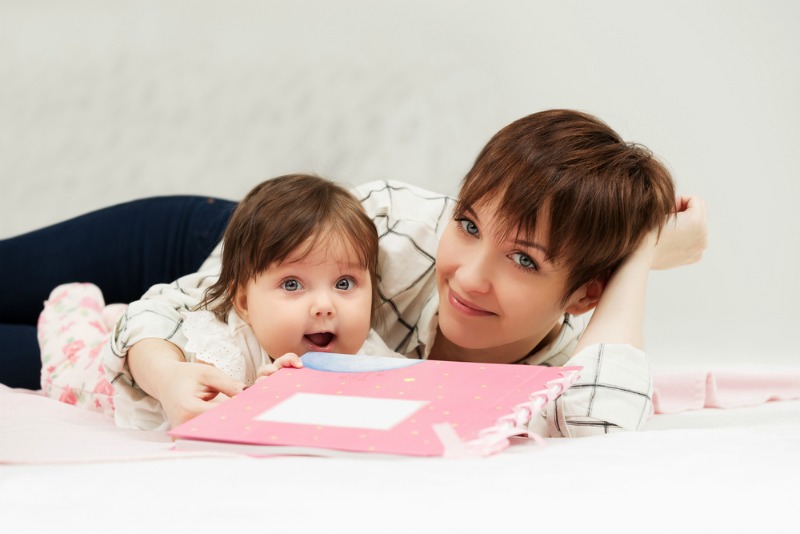 Image d'un bébé au lit en train de lire / lire à votre enfant