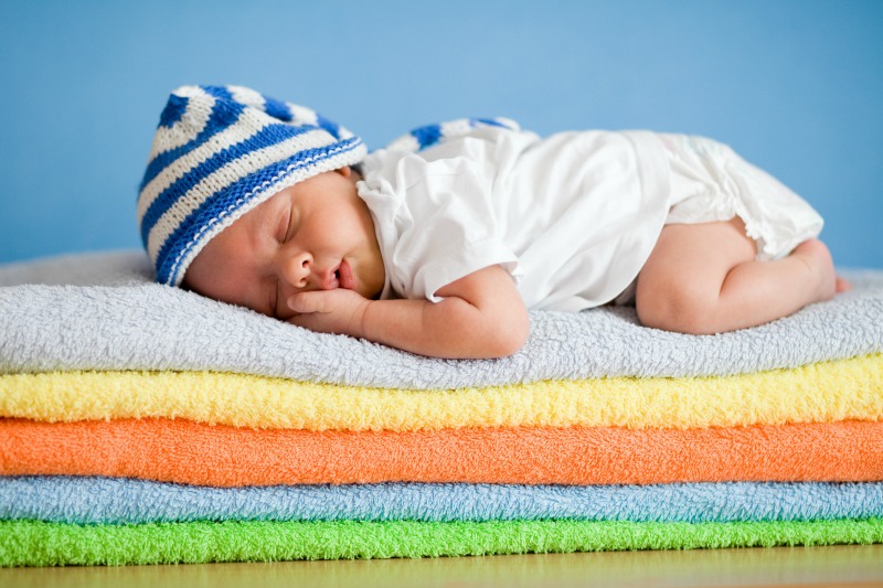 Image of a baby sleeping on a pile of towels