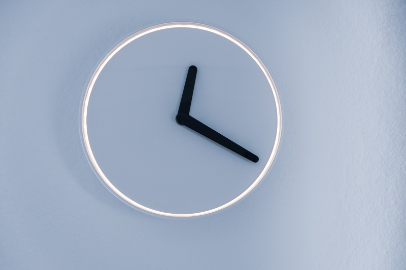 A modern clock superimposed onto a light blue wall