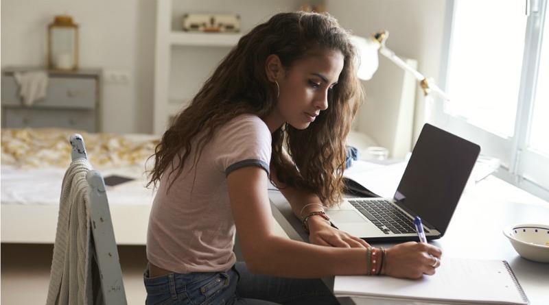 Teenager working at her desk in bedroom