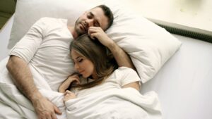 Couple sleeping together in bed.