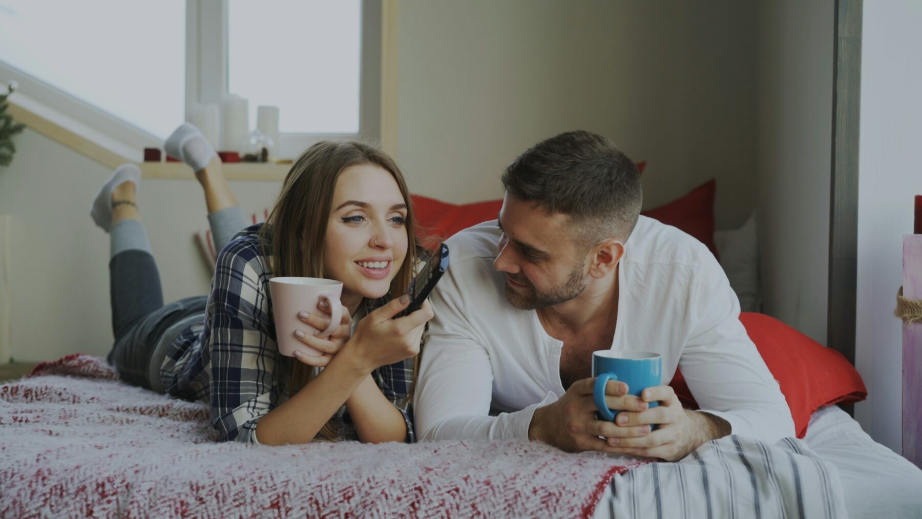 Couple drinking coffee in bed.