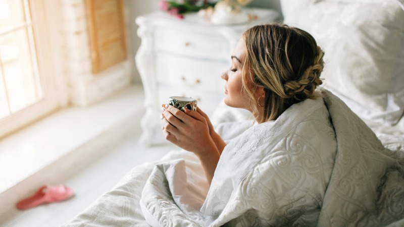 Woman drinking tea in bed