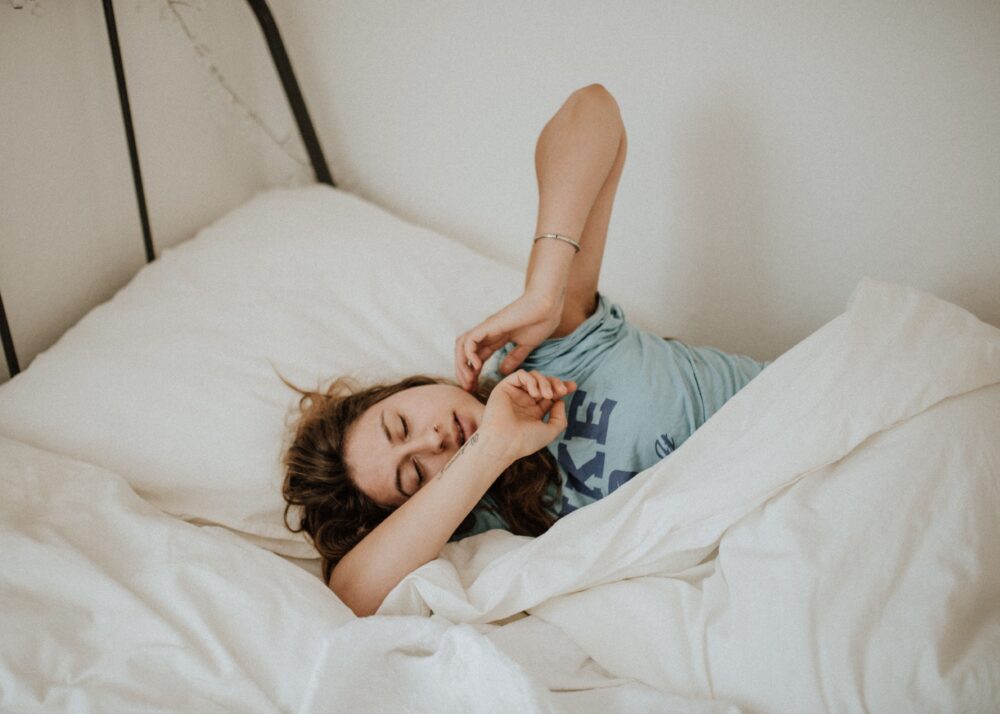 A woman waking up in a bed.