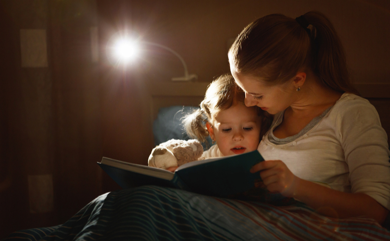 Woman reading bedtime story to child