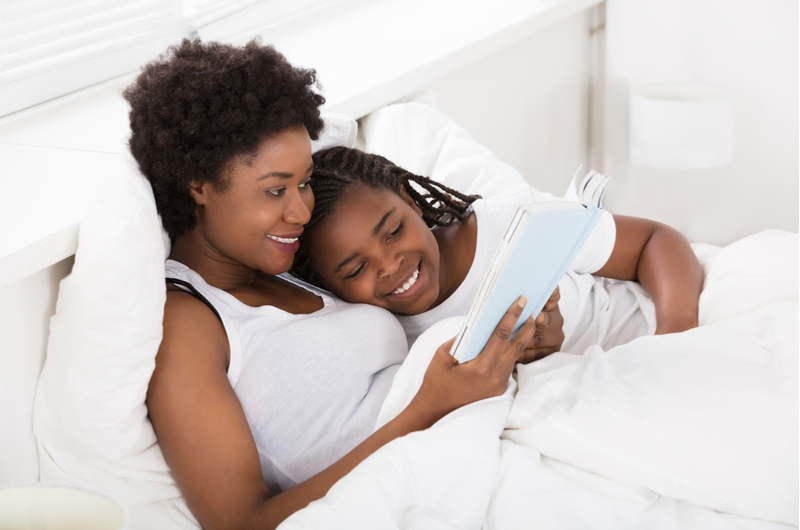 Woman reading her daughter a bedtime story