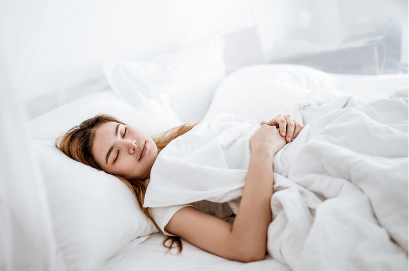 Woman sleeping in white bed